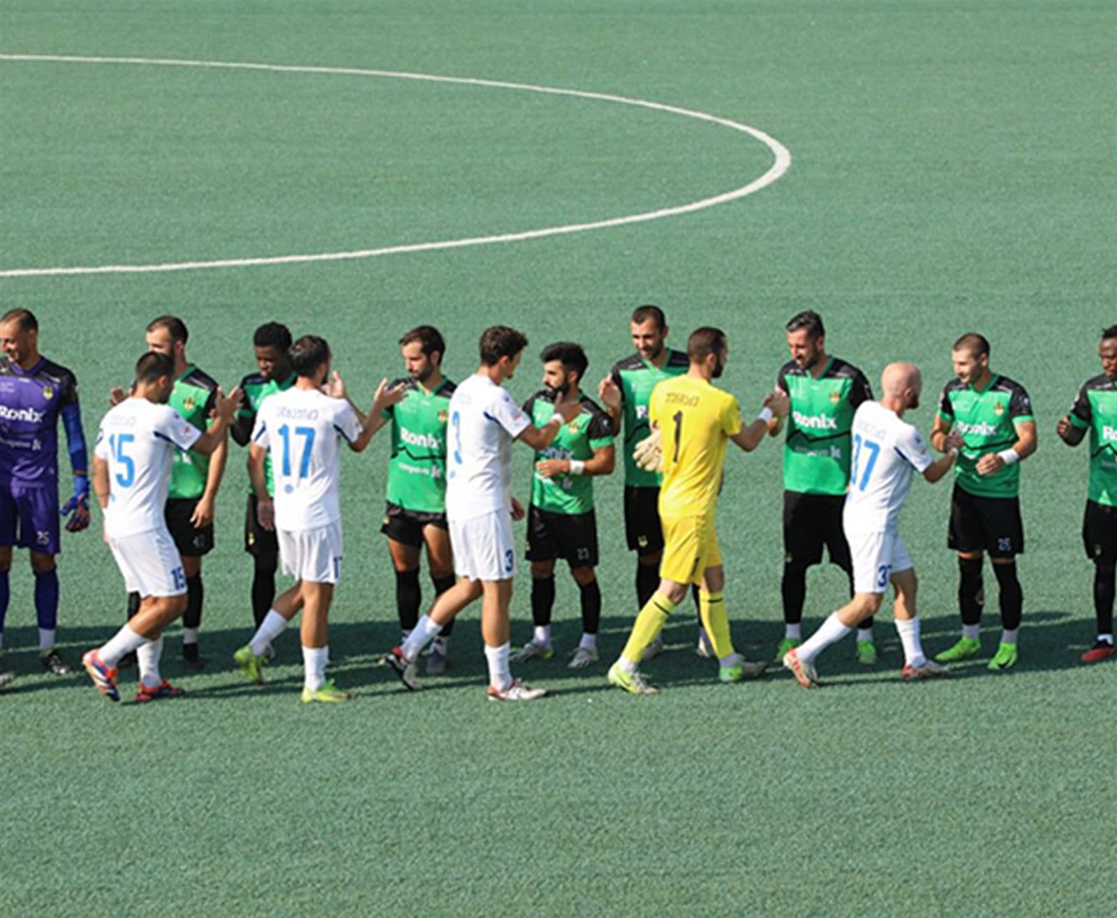 Two teams lined up on the pitch before kick-off